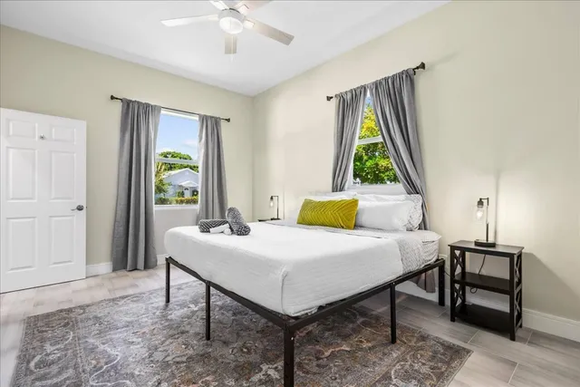 a bedroom with a large bed a flat tv screen and chandelier