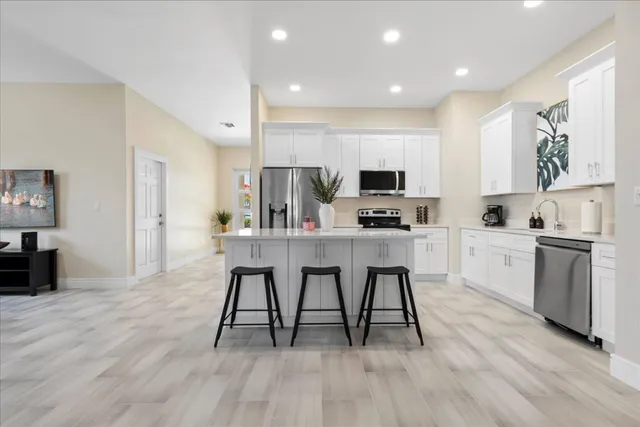 a kitchen with white cabinets and sink