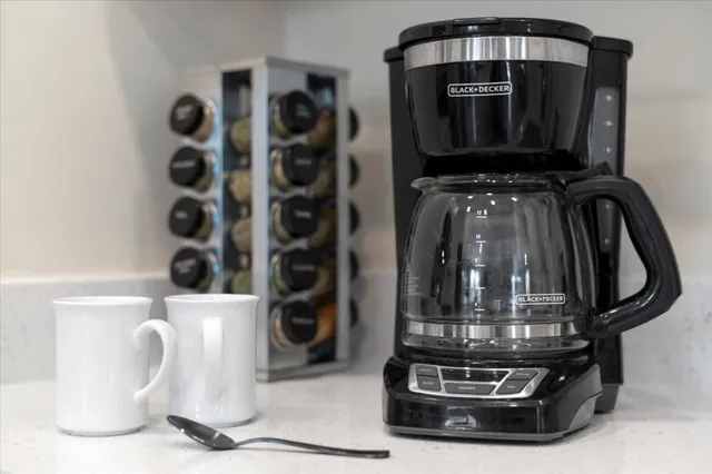 a kitchen with white cabinets and dining table