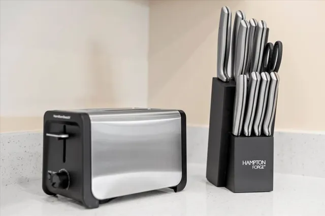 a kitchen with stainless steel appliances granite countertop a stove top oven a sink a dining table and chairs with wooden floor