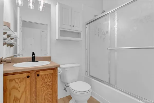 a bathroom with a granite countertop sink toilet and a mirror