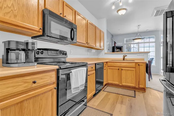 a kitchen with stainless steel appliances granite countertop a sink a stove and cabinets