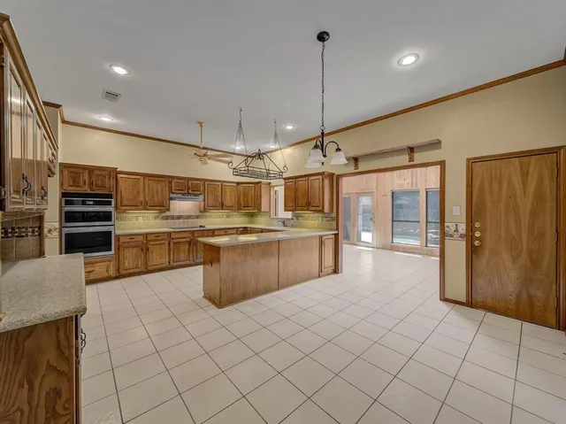 a kitchen with stainless steel appliances a sink a counter top space cabinets and a view of living room