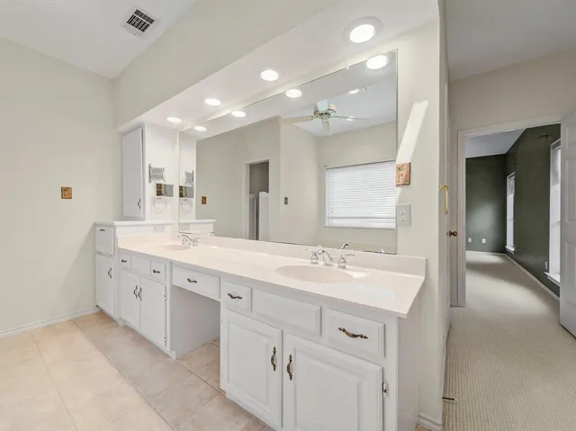 a spacious bathroom with a double vanity sink mirror and double