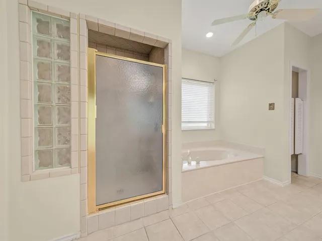 a bathroom with a tub shower and mirror