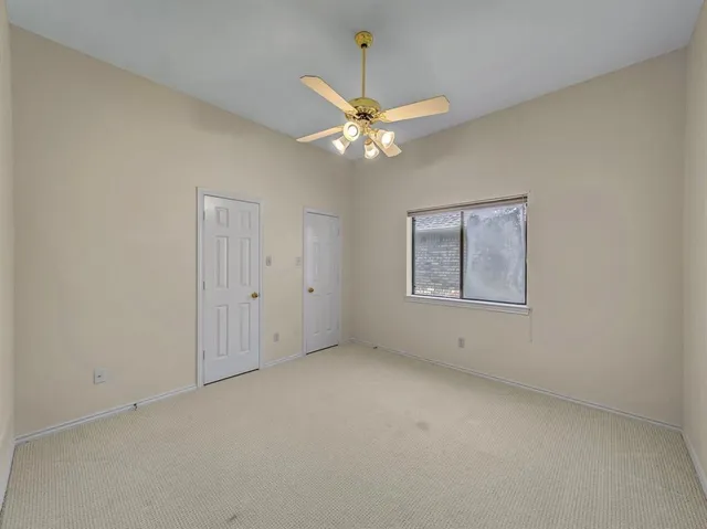 an empty room with a window and a fan