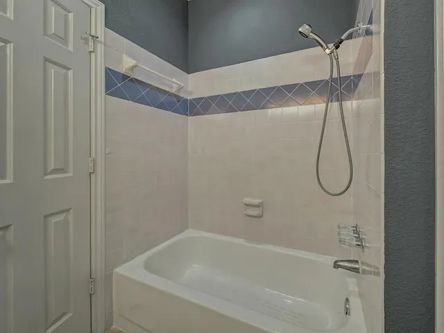 a bathroom with a bath tub with shower