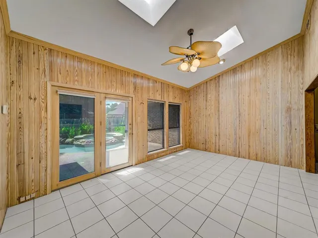 a view of an empty room and chandelier fan