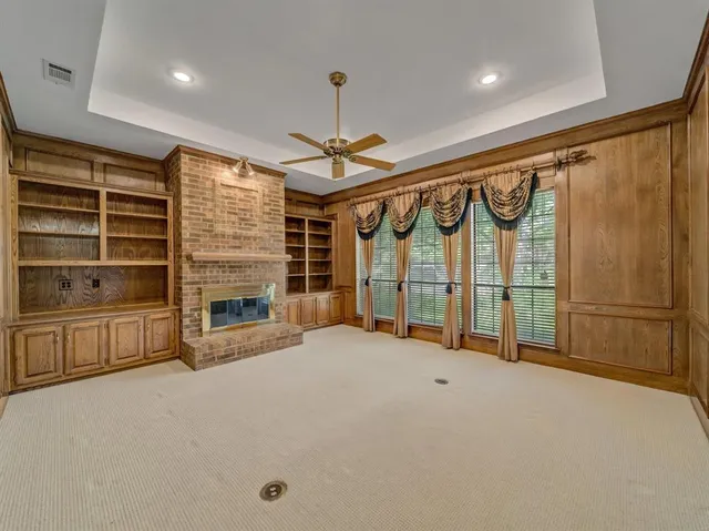 a view of an empty room with a fireplace and a window