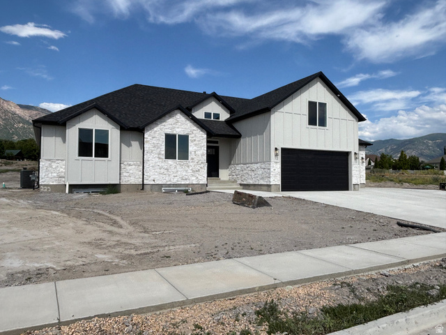 1184 West 3250 North Ogden, UT 84414 - Photo 3 of 69 Modern farmhouse exterior featuring white board and batten siding, stone facade accents, and a dark shingle roof