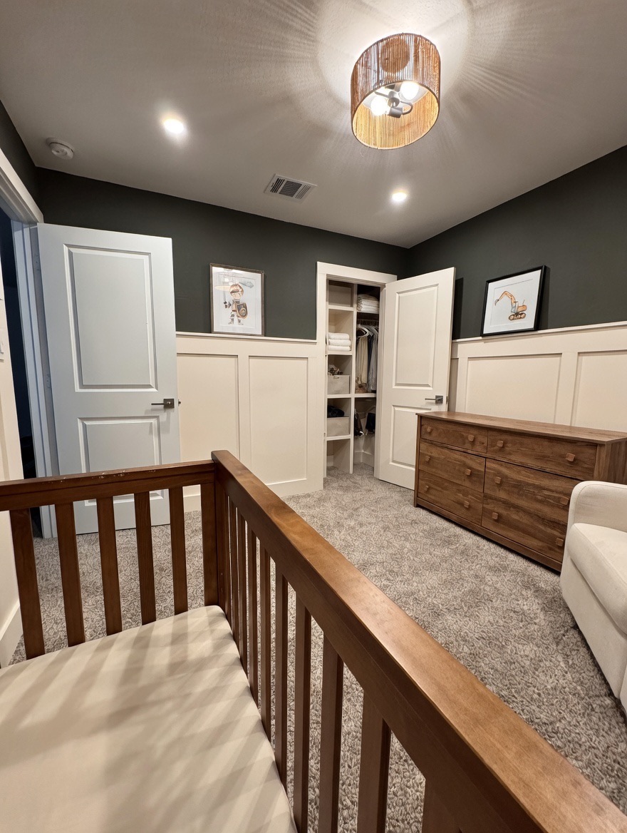 13513 Menard Way Elgin, TX 78621 - Photo 13 of 18 Bedroom with light carpet, a closet, a decorative wall, and wainscoting