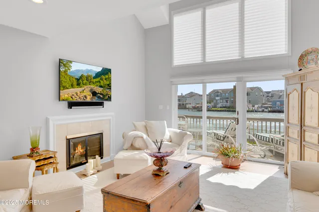 a living room with furniture a fireplace and a floor to ceiling window