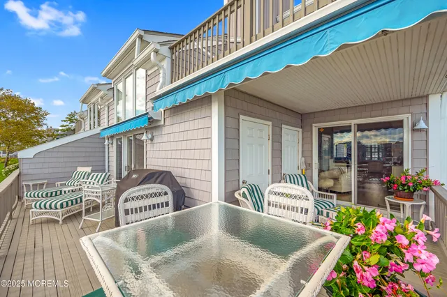 a front view of house along with deck and outdoor seating