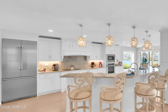 a kitchen with stainless steel appliances granite countertop a sink and a refrigerator