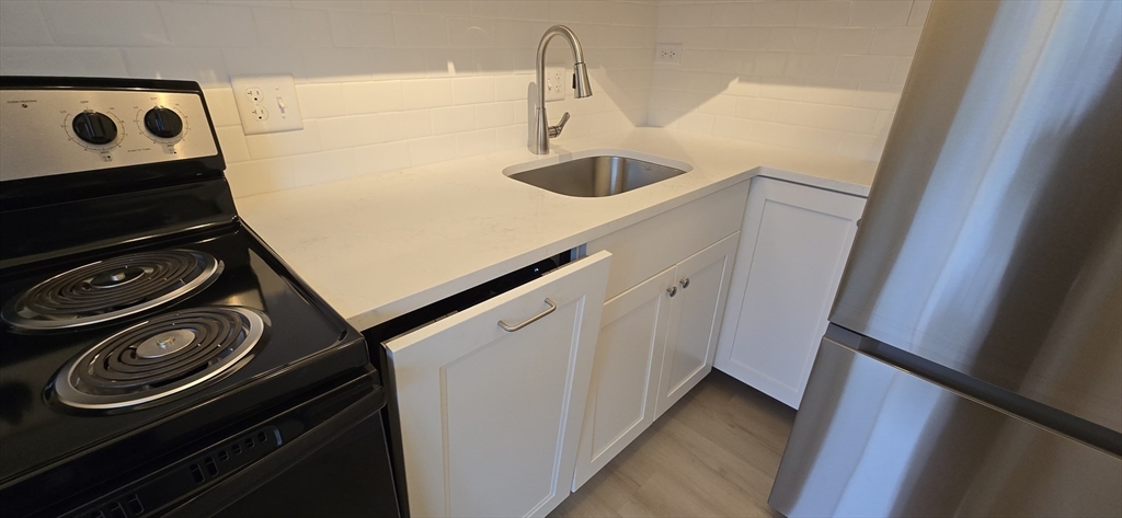 14 Concord Avenue, Unit 312 Cambridge, MA 02138 - Photo 11 of 19 a kitchen with a sink and a stove top oven