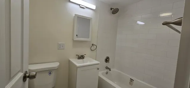 a bathroom with a sink and mirror with toilet