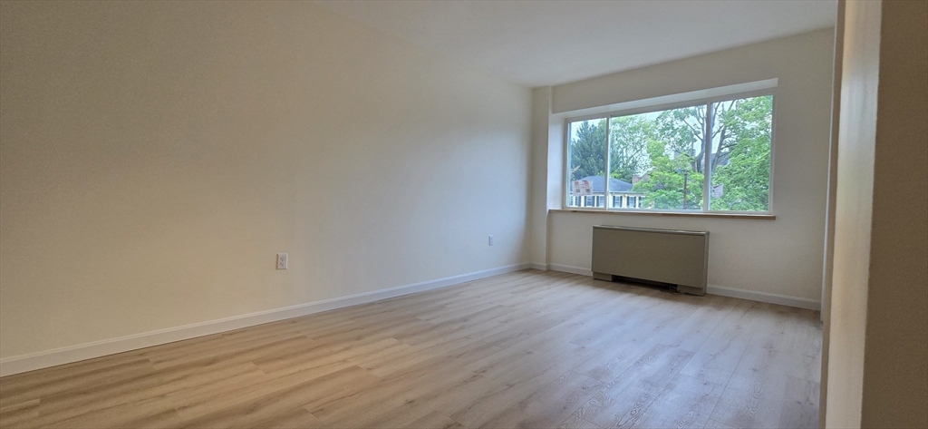 14 Concord Avenue, Unit 312 Cambridge, MA 02138 - Photo 17 of 19 an empty room with wooden floor and windows