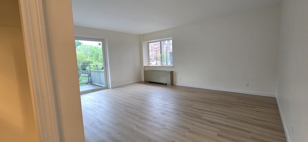 14 Concord Avenue, Unit 312 Cambridge, MA 02138 - Photo 4 of 19 a view of an empty room with wooden floor and a window