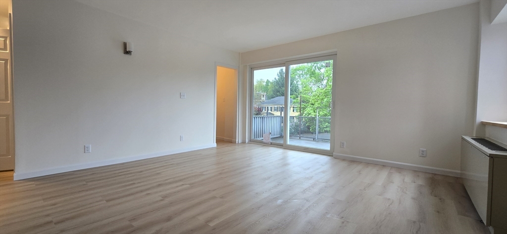 14 Concord Avenue, Unit 312 Cambridge, MA 02138 - Photo 5 of 19 a view of an empty room with wooden floor and a window