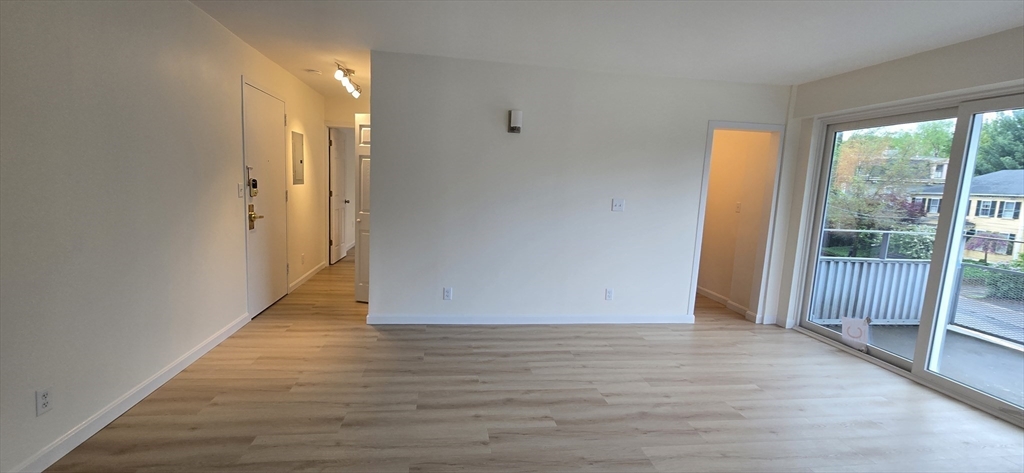 14 Concord Avenue, Unit 312 Cambridge, MA 02138 - Photo 6 of 19 a view of an empty room with wooden floor and a window