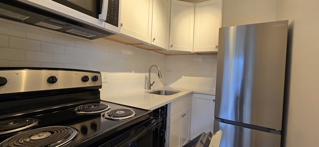 14 Concord Avenue, Unit 312 Cambridge, MA 02138 - Photo 10 of 19 a kitchen with a stove and a refrigerator