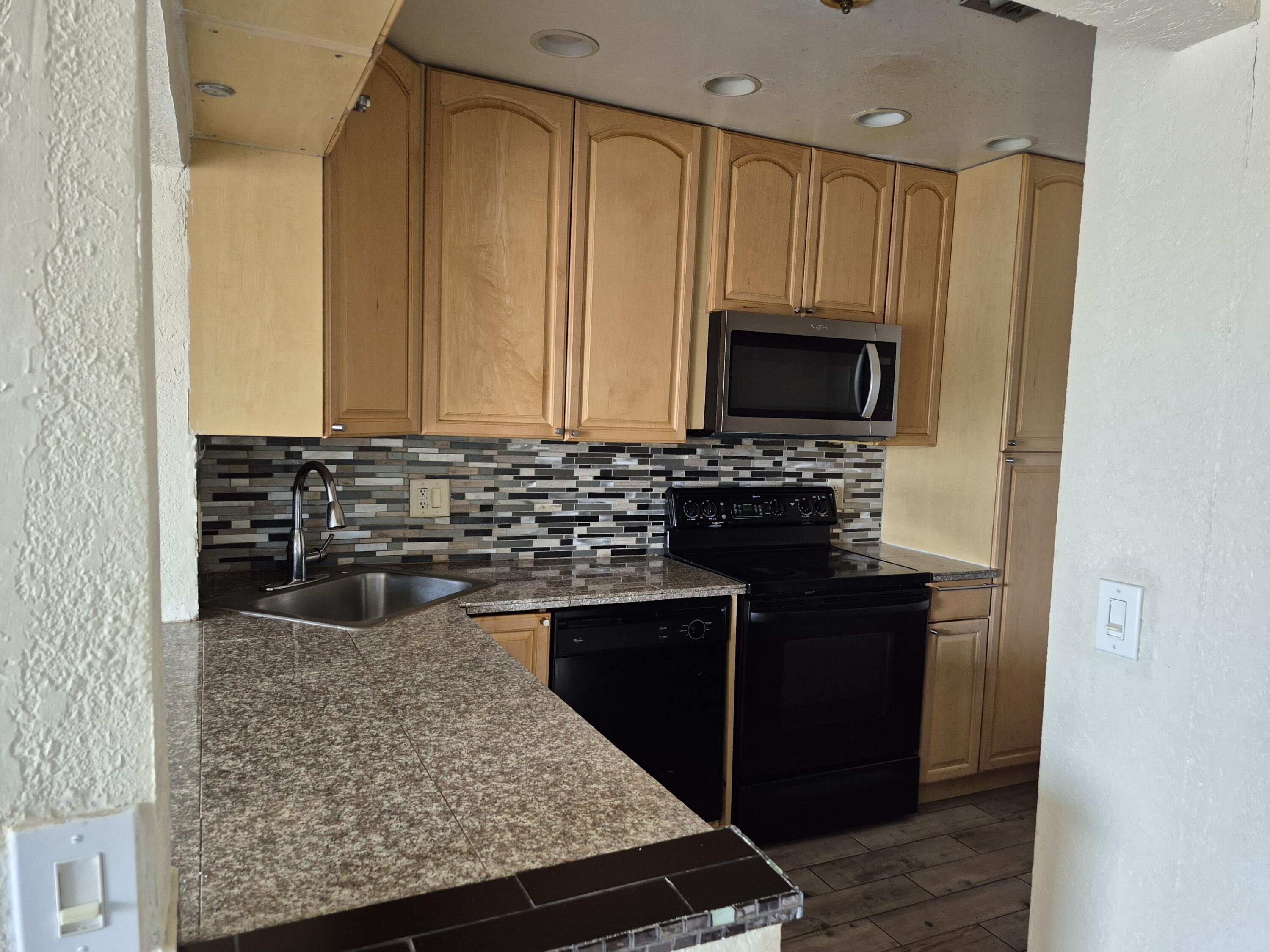 10039 Winding Lake Road, Unit 202 Sunrise, FL 33351 - Photo 7 of 14 a kitchen with a sink stove and microwave