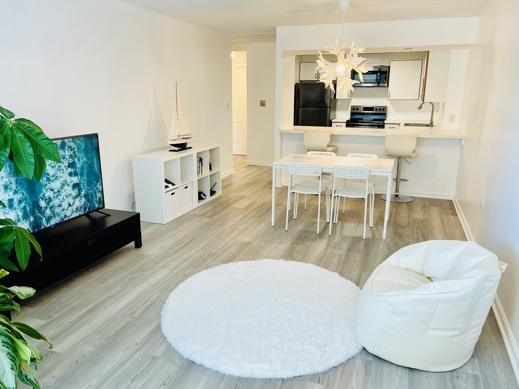 155 George Washington Boulevard, Unit 607 Hull, MA 02045 - Photo 1 of 22 a living room with furniture a dining table and a potted plant
