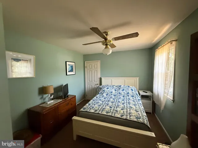 a bathroom with a sink a toilet a window and vanity