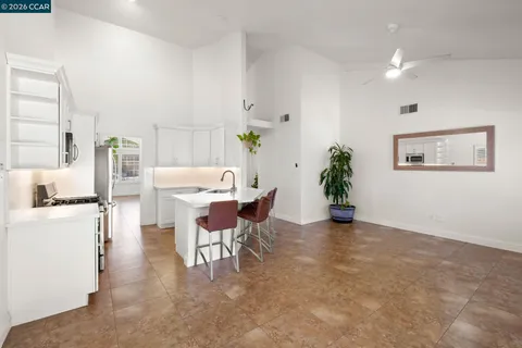 a hallway with cabinets a flat screen tv and a potted plant