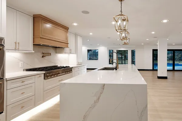 a large kitchen with stainless steel appliances granite countertop a stove and a sink with granite countertops