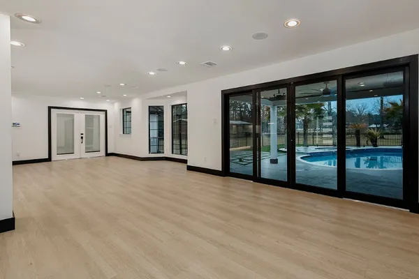 an empty room with wooden floor and windows