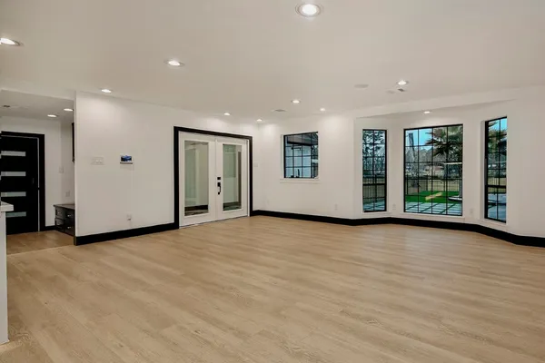 a view of an empty room with wooden floor and cabinet