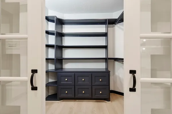 a view of an empty room with a window and cabinet
