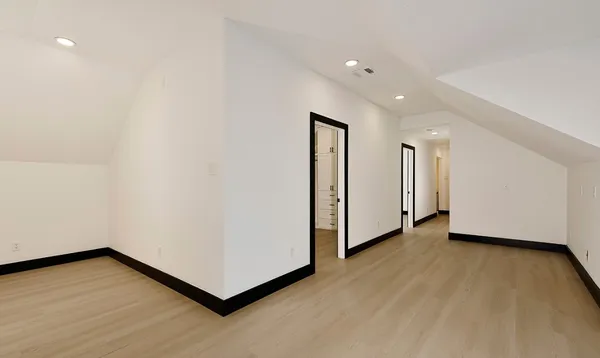 a view of an empty room with wooden floor