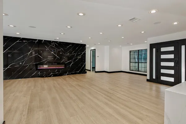 a view of an empty room with wooden floor