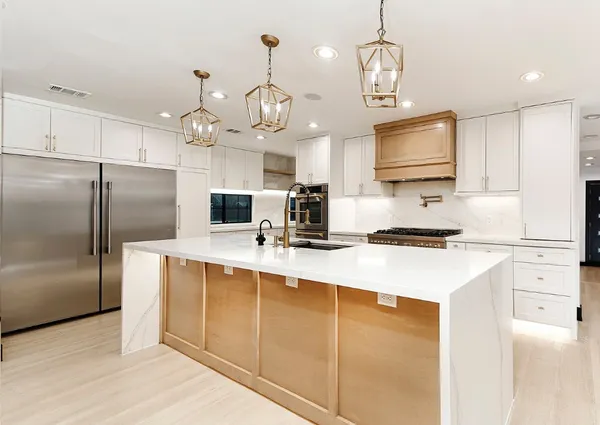 a kitchen with stainless steel appliances a refrigerator sink and microwave