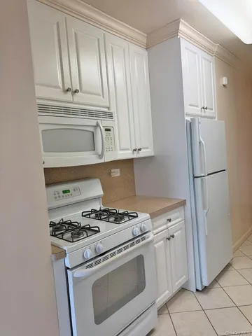 a kitchen with white cabinets and white appliances