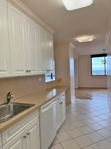 a kitchen with stainless steel appliances granite countertop a sink and dishwasher with white cabinets