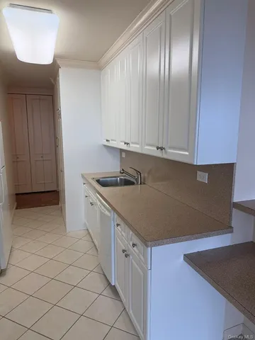 a kitchen with granite countertop white cabinets and white appliances