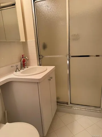 a bathroom with a sink a toilet a mirror and shower