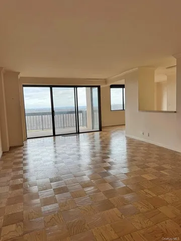 a view of empty room with window and wooden floor