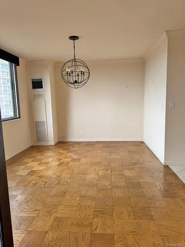 a view of empty room with wooden floor and window