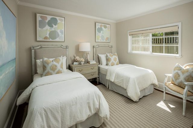 a bedroom with two beds and a window