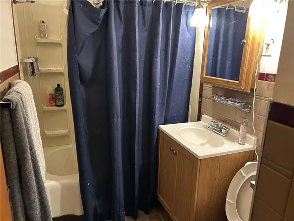 a bathroom with sink a mirror a toilet and a window