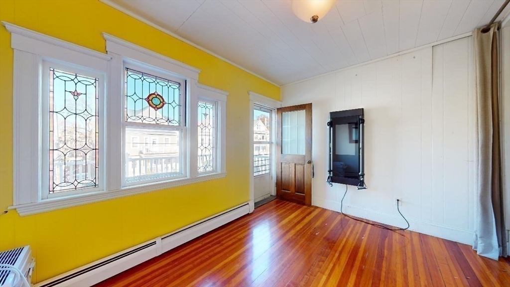 17 Gorham Road, Unit 2 Medford, MA 02155 - Photo 20 of 37 a view of an empty room with window and wooden floor