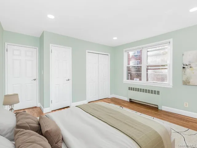 a bedroom with a bed and a window with chair