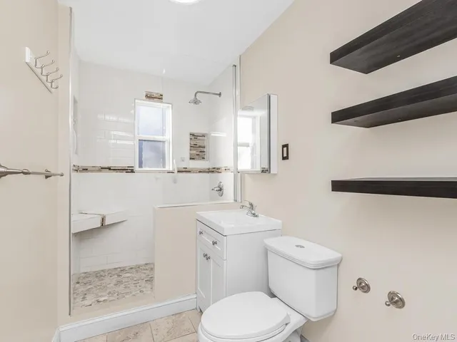 a bathroom with a sink a toilet a mirror and shower