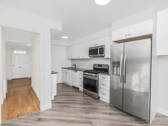 a kitchen with white cabinets and stainless steel appliances
