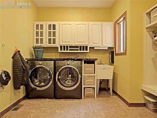 735 Winding Hills Road Monument, CO 80132 - Photo 20 of 42 Laundry room comes with concrete countertops, washer & dryer, utility sink, built-in cubbies for coats and back packs.