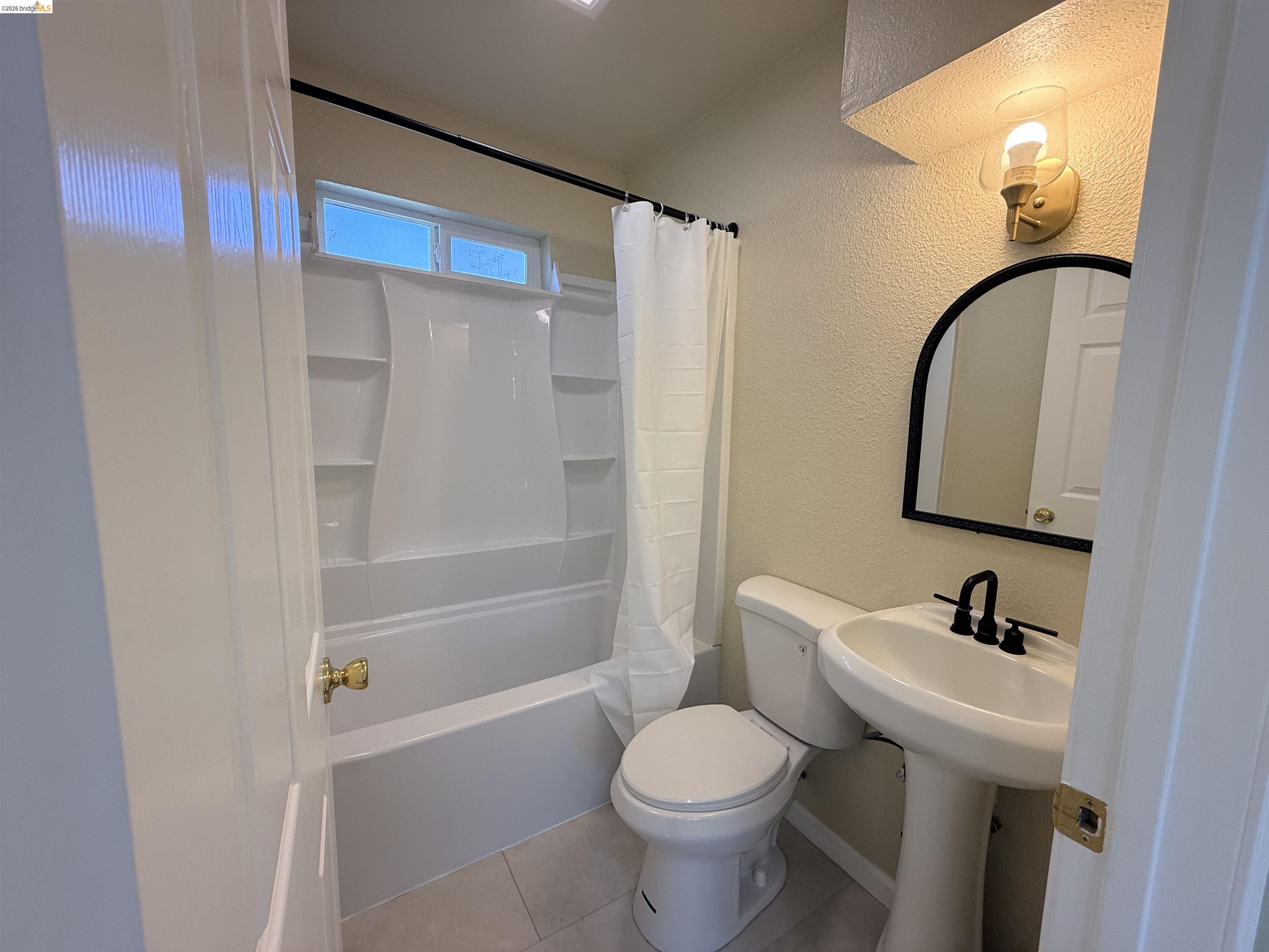 321 Benicia Road Vallejo, CA 94590 - Photo 11 of 48 Full bathroom featuring a textured wall, shower / bath combo, and light tile patterned floors